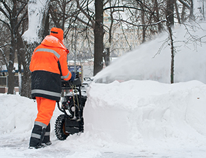 Man operating snow blower